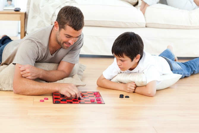 Father and son playing board game Tatin sin