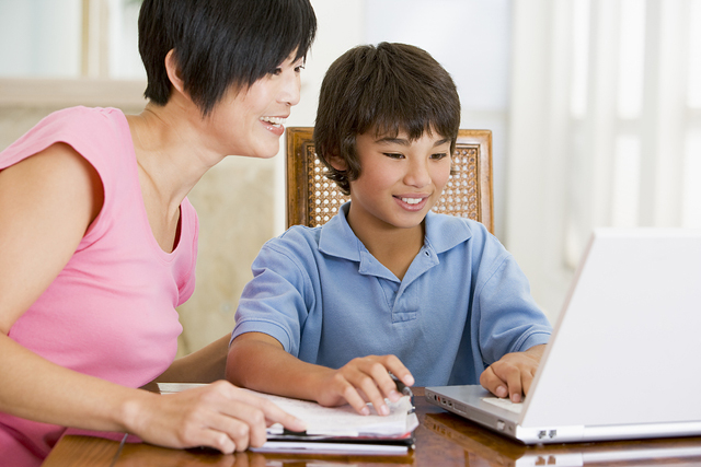 Mom helping son with homework Da li da pomažemo deci oko domaćeg?